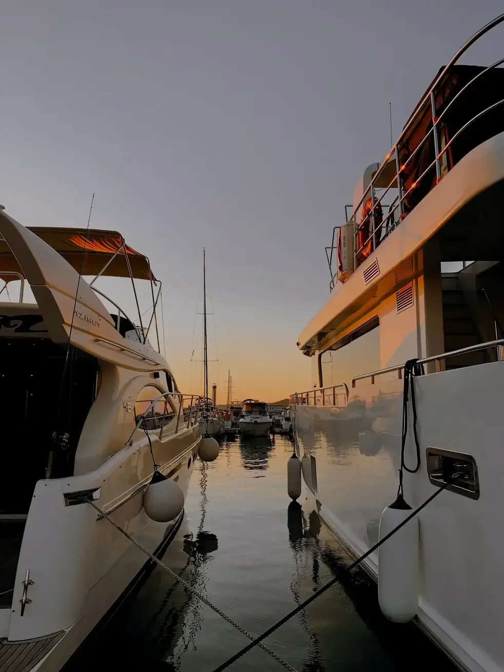 Yachtinspektor mit Tablet neben einer Motorjacht am Liegeplatz